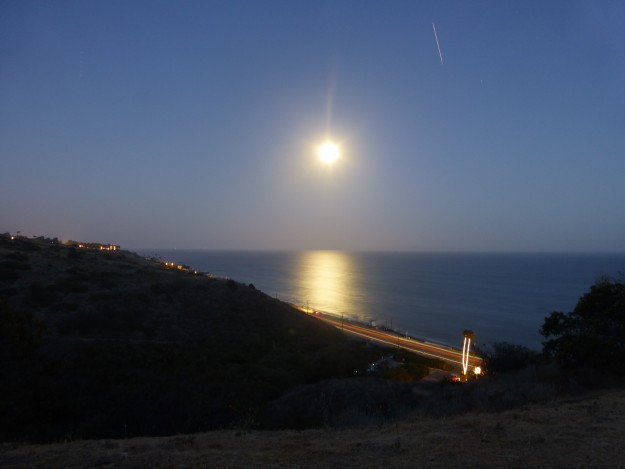 Super moon right at dusk with a dark blue sky.