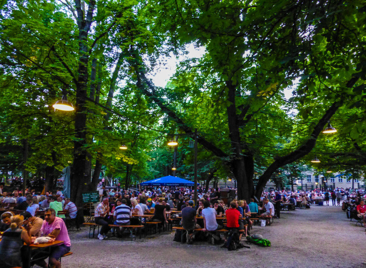 Huge trees framing picnic tables at Augustiner-Keller in Munich. 