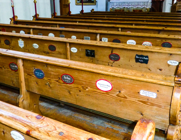 Labeled pews inside Church of St. Paul and St. Peter in Mittenwald. 
