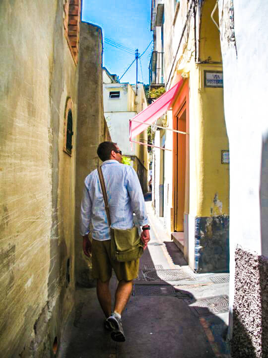 Stylish man exploring Capri, Italy wearing clothing items packing in just a carry-on. 