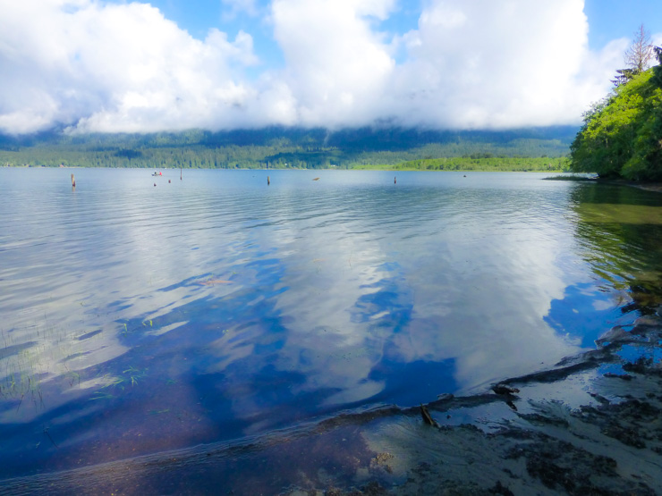 Lake Quinault with the Olympic mountain range partially camouflaged by clouds. 