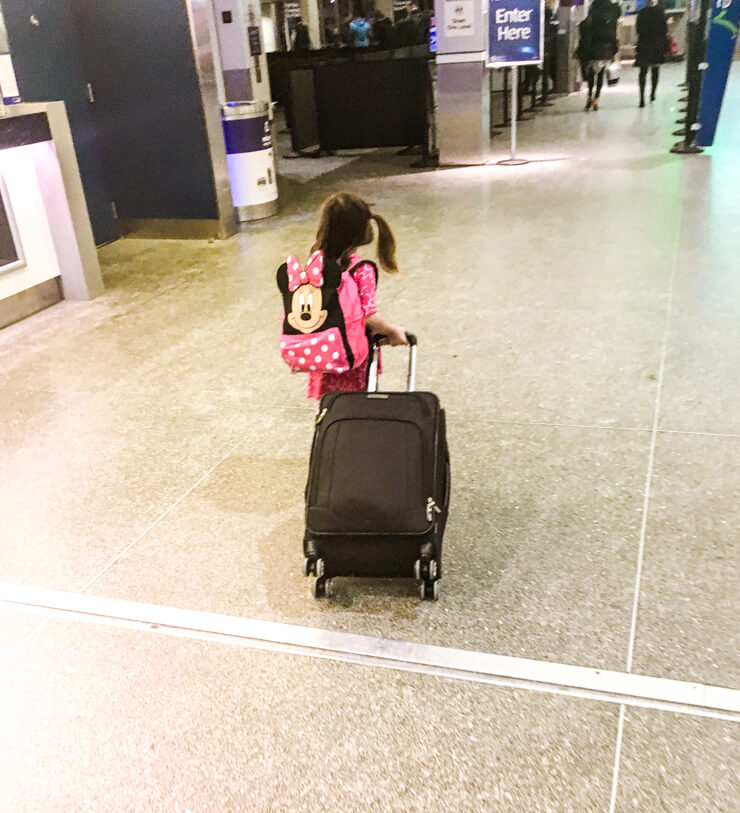 When packing while traveling with kids, get your child their own luggage! She was so proud to wear her backpack and insisted on pulling our carry-on suitcase through the airport.