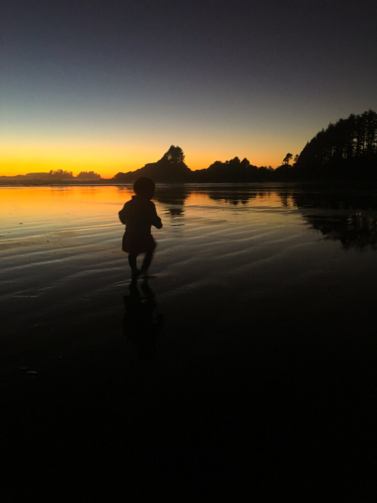 Toddler running around on the beach during a Tofino sunset in British Columbia