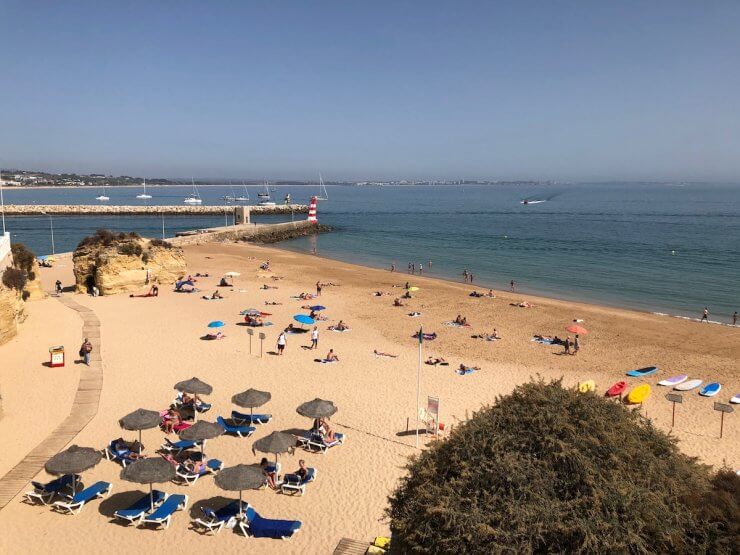 Serene beach in Lagos, Portugal with beach umbrellas and sunbathers