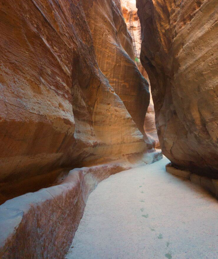 Footprints in the sand going through the Siq Trail to Petra. 