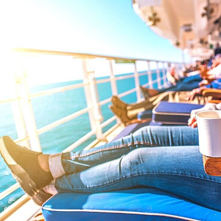 Group of travelers relaxing on a cruise ship terrace.