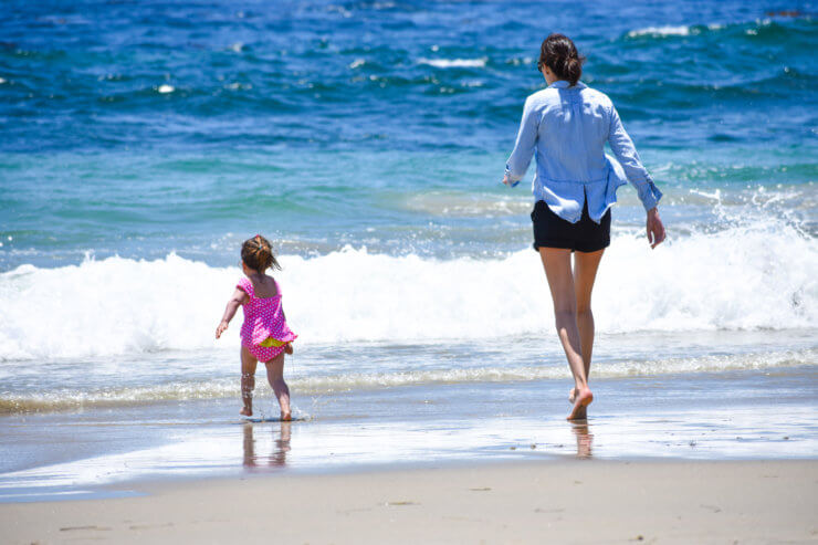 Running along the soft sand beach into aqua waves in Laguna Beach, CA. 