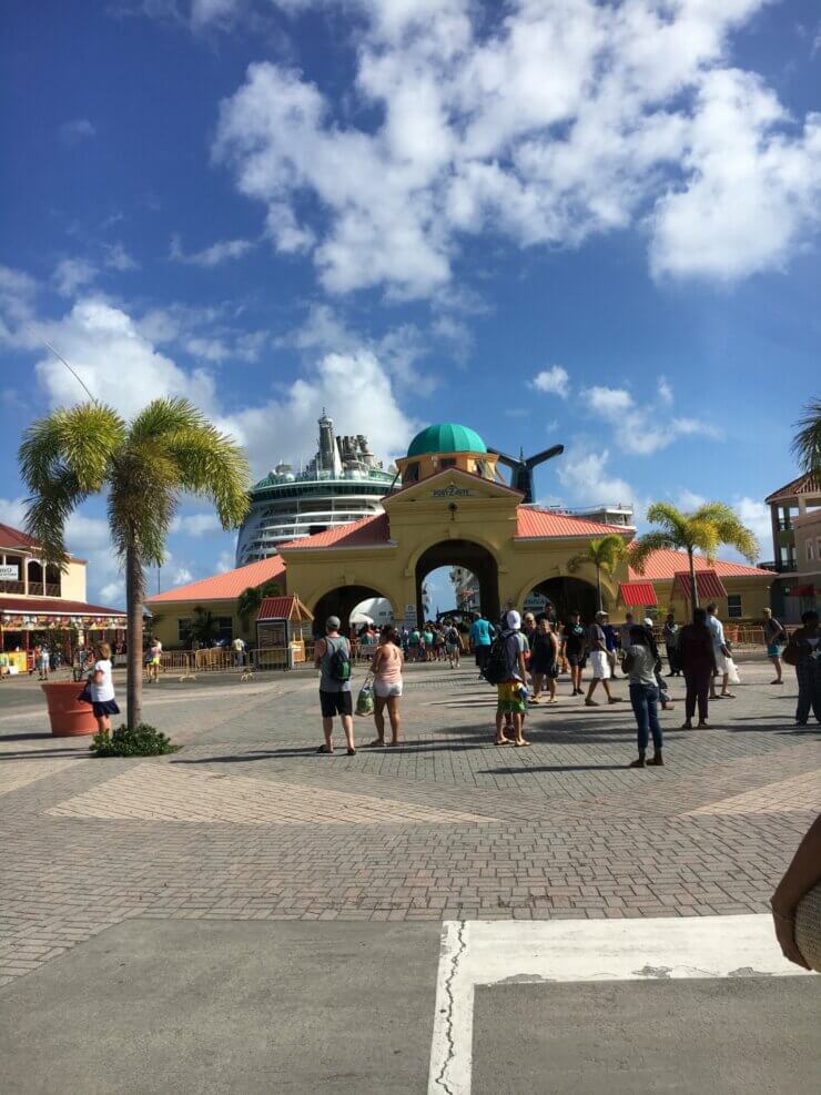 People walking around the cruise port of Curacao with a ship in the background. 