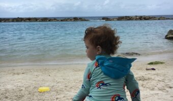 Toddler with packed beach attire during a Caribbean cruise