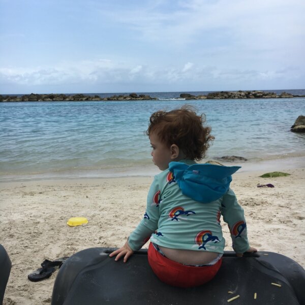 Toddler with packed beach attire during a Caribbean cruise