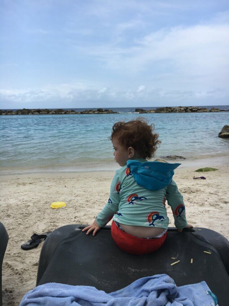 What to pack during a Caribbean cruise for families: Toddler wearing packed beach gear during a Caribbean cruise shore excursion. 